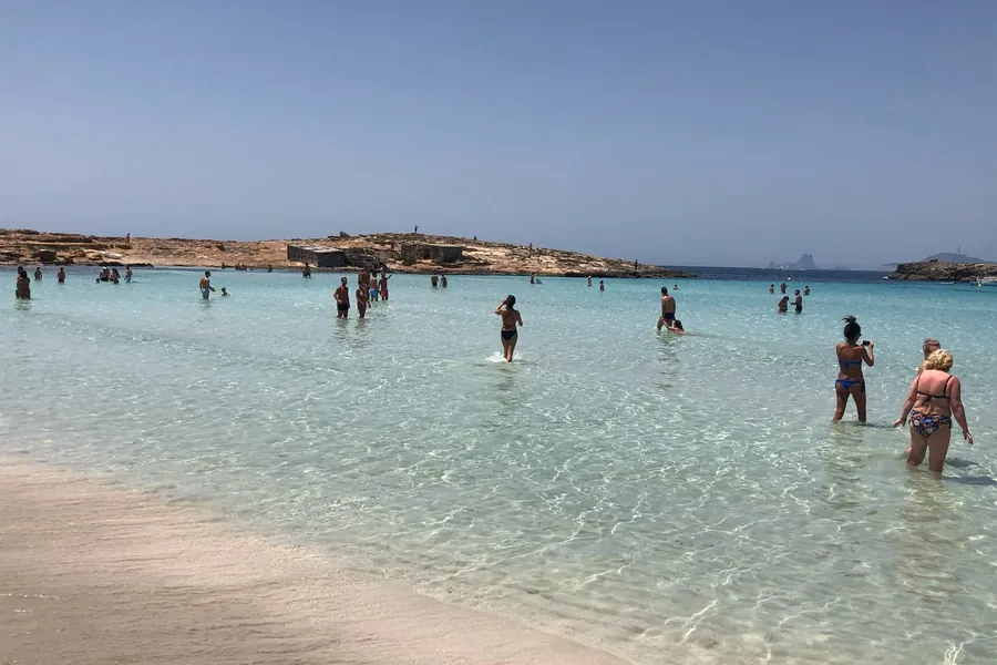 Shallow lagoon of Ses Illetes with the rocky islet in the background