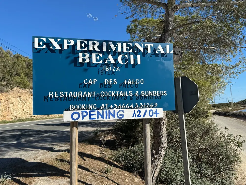 Sign for Experimental Beach at Cap des Falco near Salinas with a note on restaurant, cocktails and sun loungers
