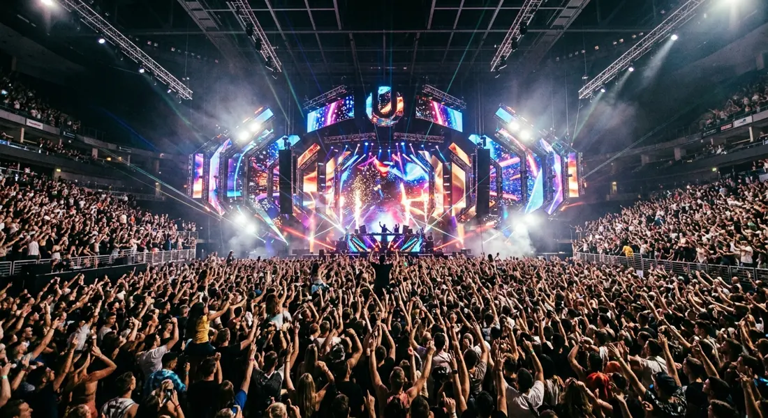 Sala de club con ambiente de arena, con un enorme escenario y público