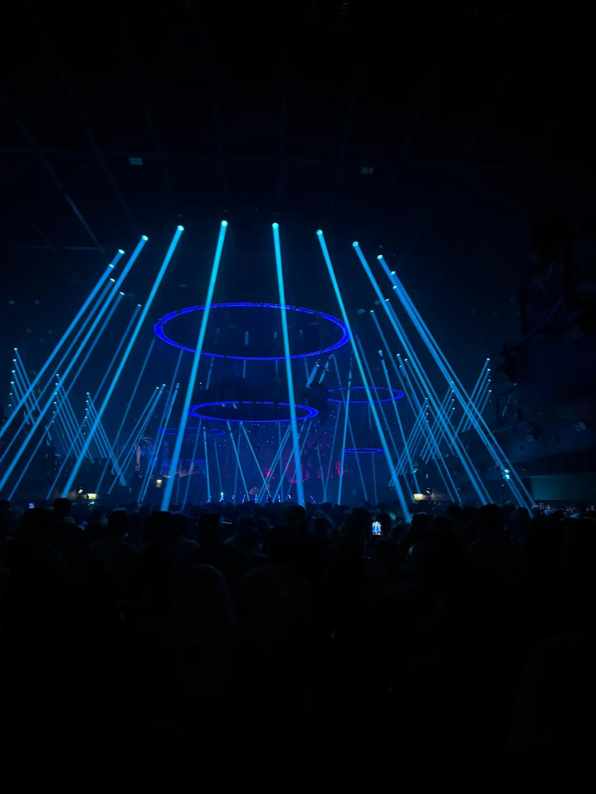 Blaue Laserstrahlen und leuchtende Ringe über der UNVRS-Tanzfläche