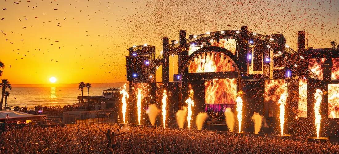 Open-Air-EDM-Bühne bei Sonnenuntergang mit großer Crowd (Symbolbild)