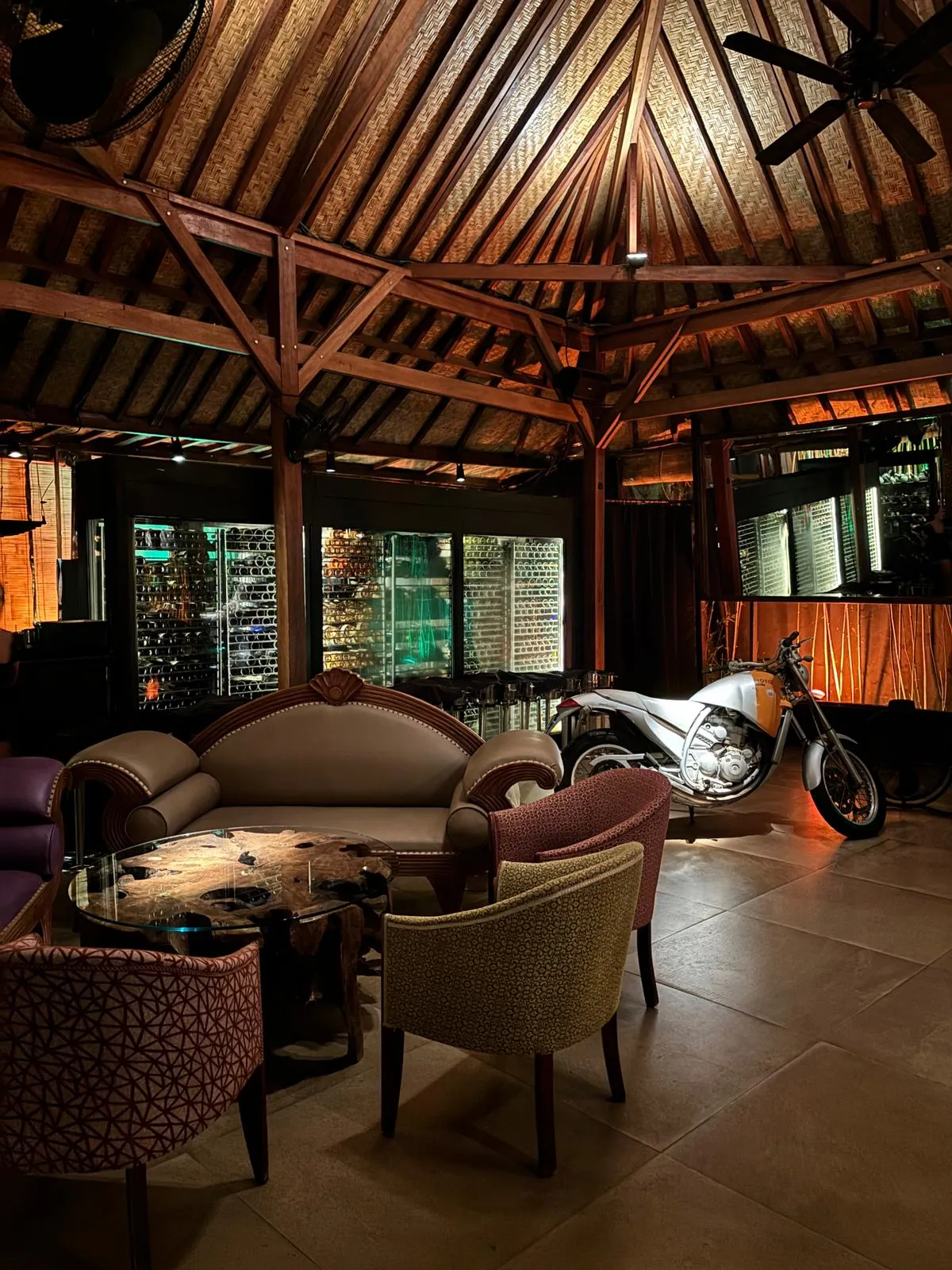 Stilvolle Lounge-Ecke mit Weinkühlschränken und Motorrad-Deko