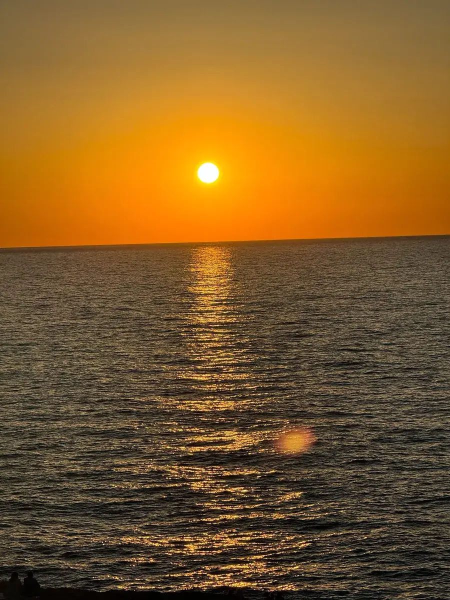 Tiefrote Abendsonne über dem Meer bei der Cala Comte