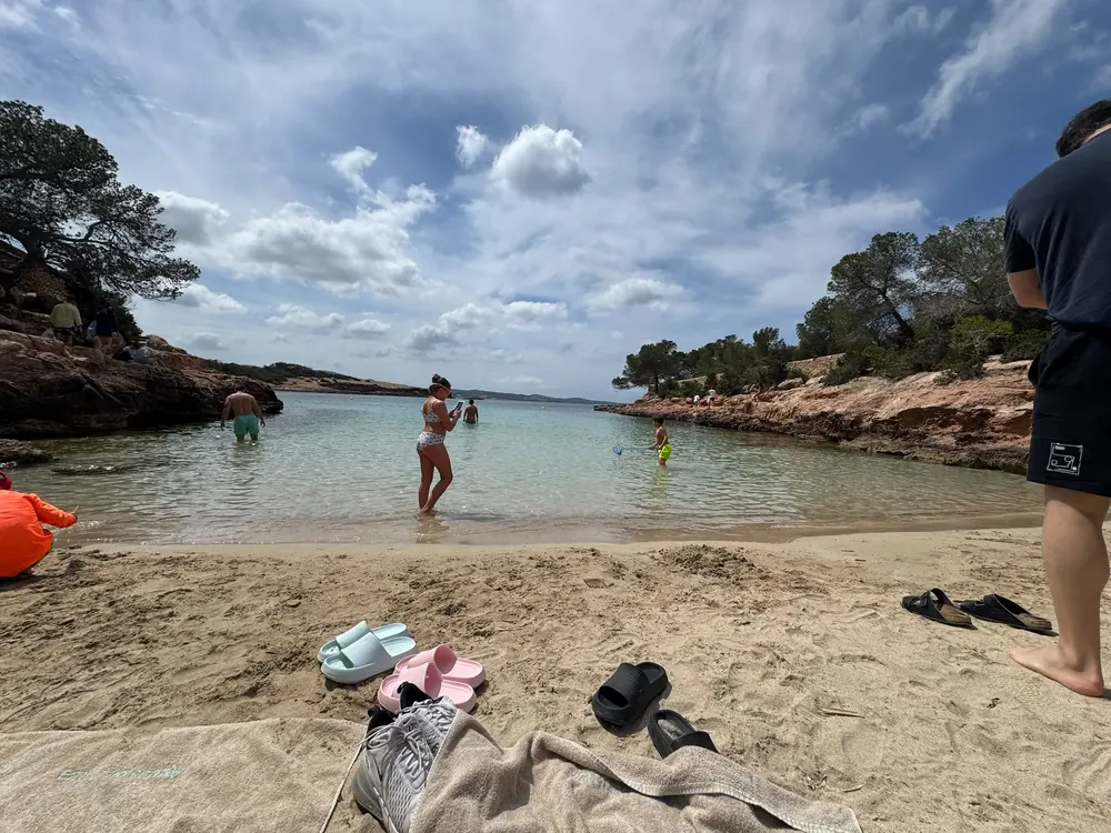 Badegäste im flachen, klaren Wasser der geschützten kleinen Bucht Cala Gracioneta