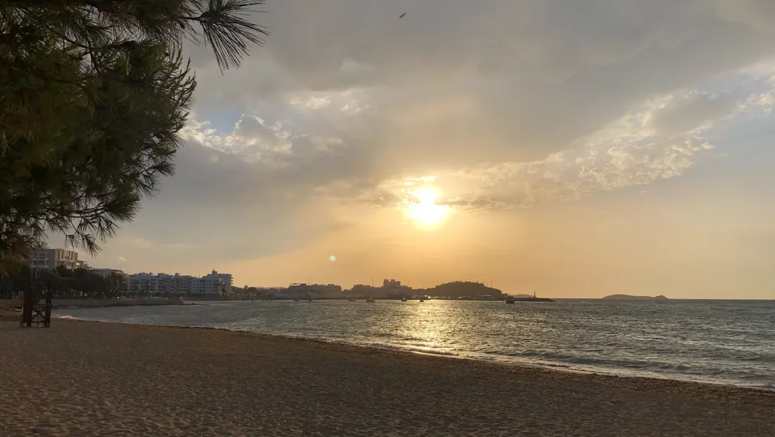 Sonnenuntergang über der Playa de Santa Eulalia mit Blick auf Ort und Bucht
